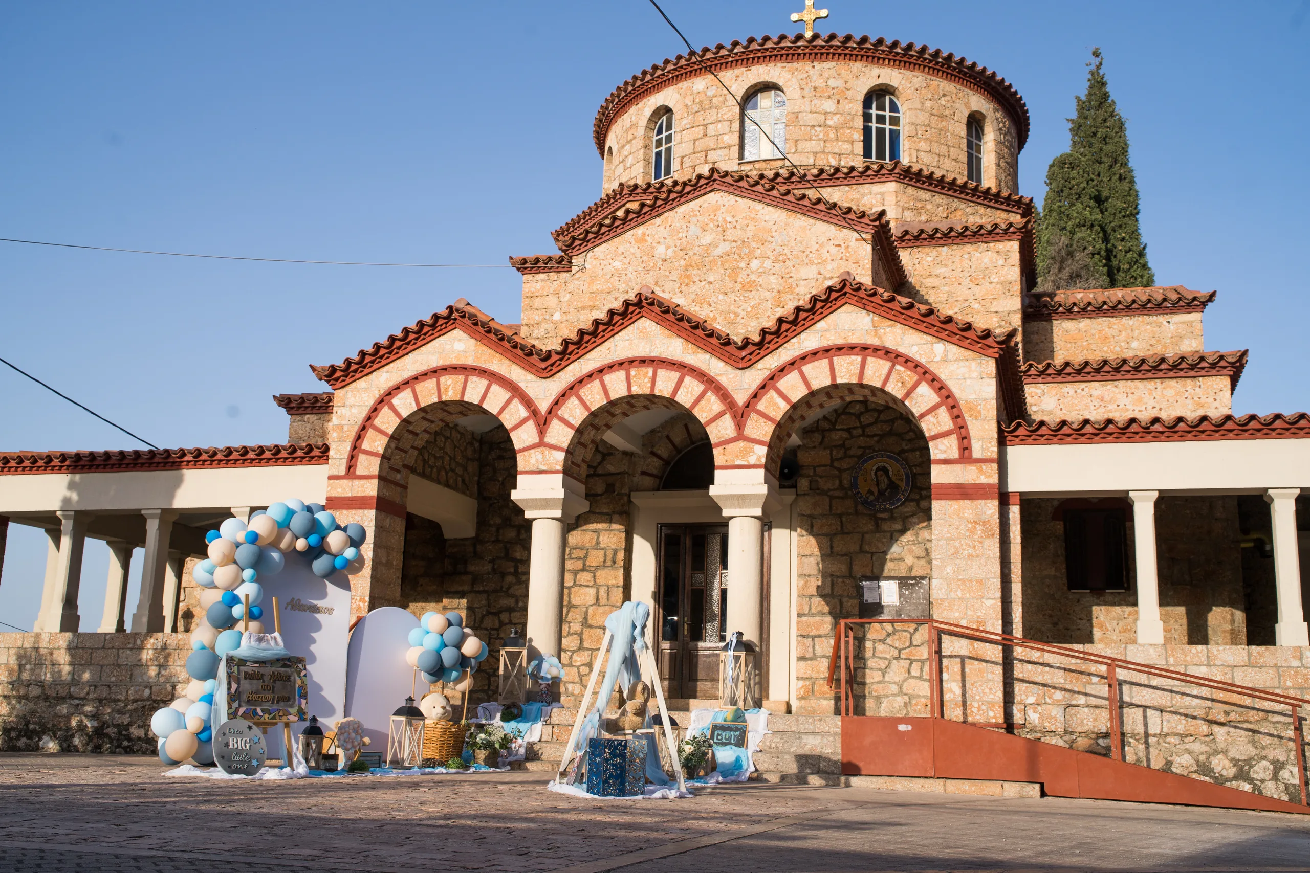 Η πέτρινη εκκλησία στολισμένη με μπλε μπαλόνια