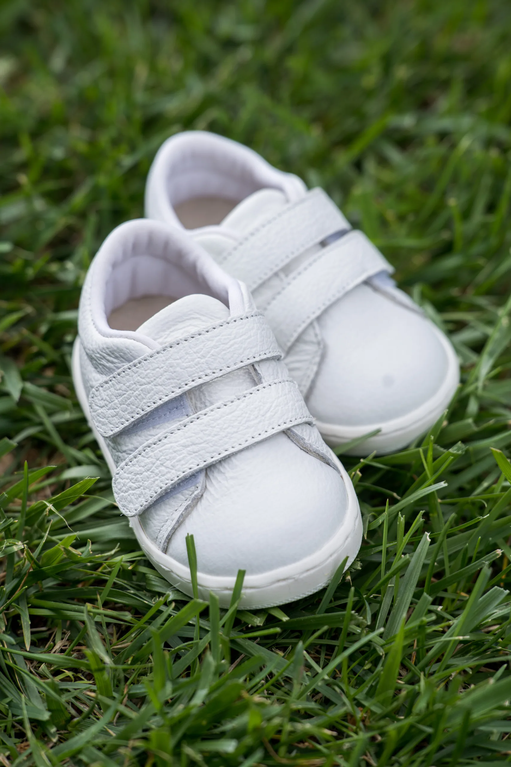 The baby's white shoes on the grass