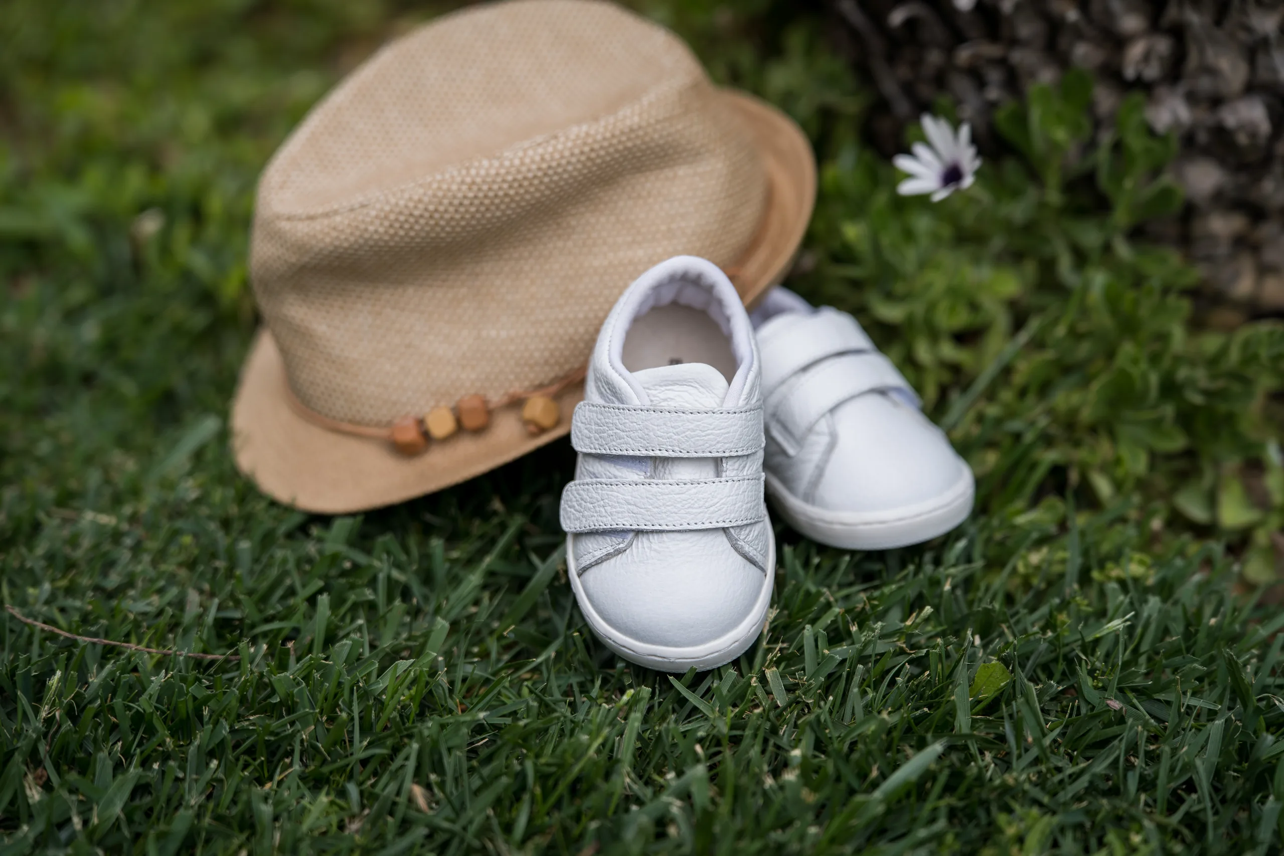 The baby's hat and shoes together on the grass