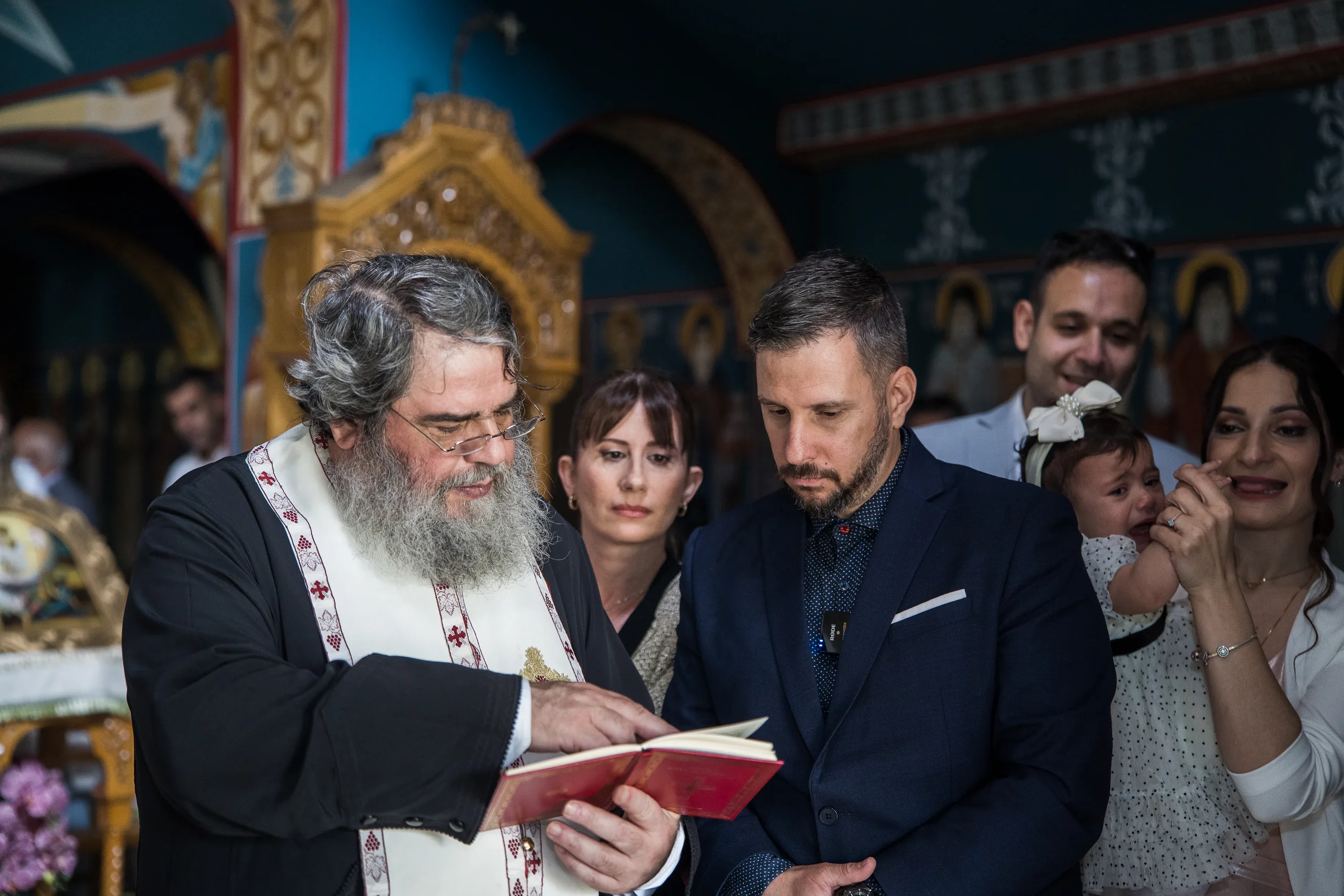 Ο ιερέας διαβάζει την ακολουθία δίπλα στην οικογένεια