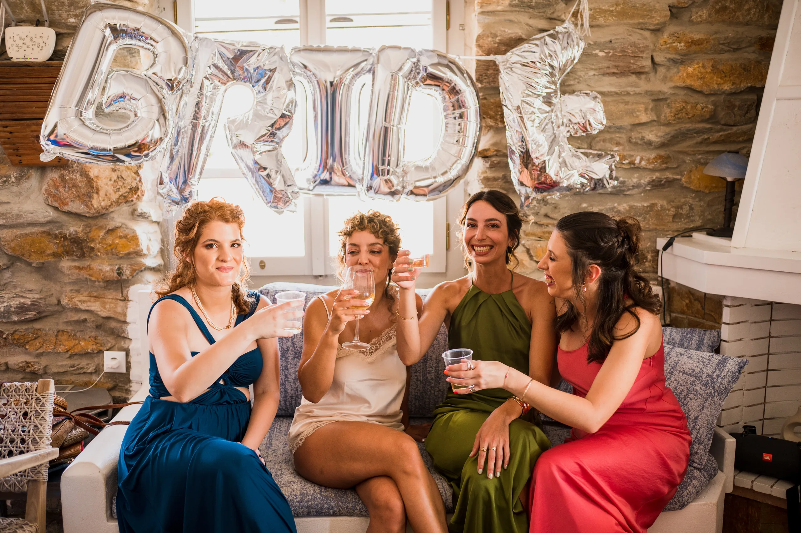 The bride and her friends raising a toast under BRIDE balloons