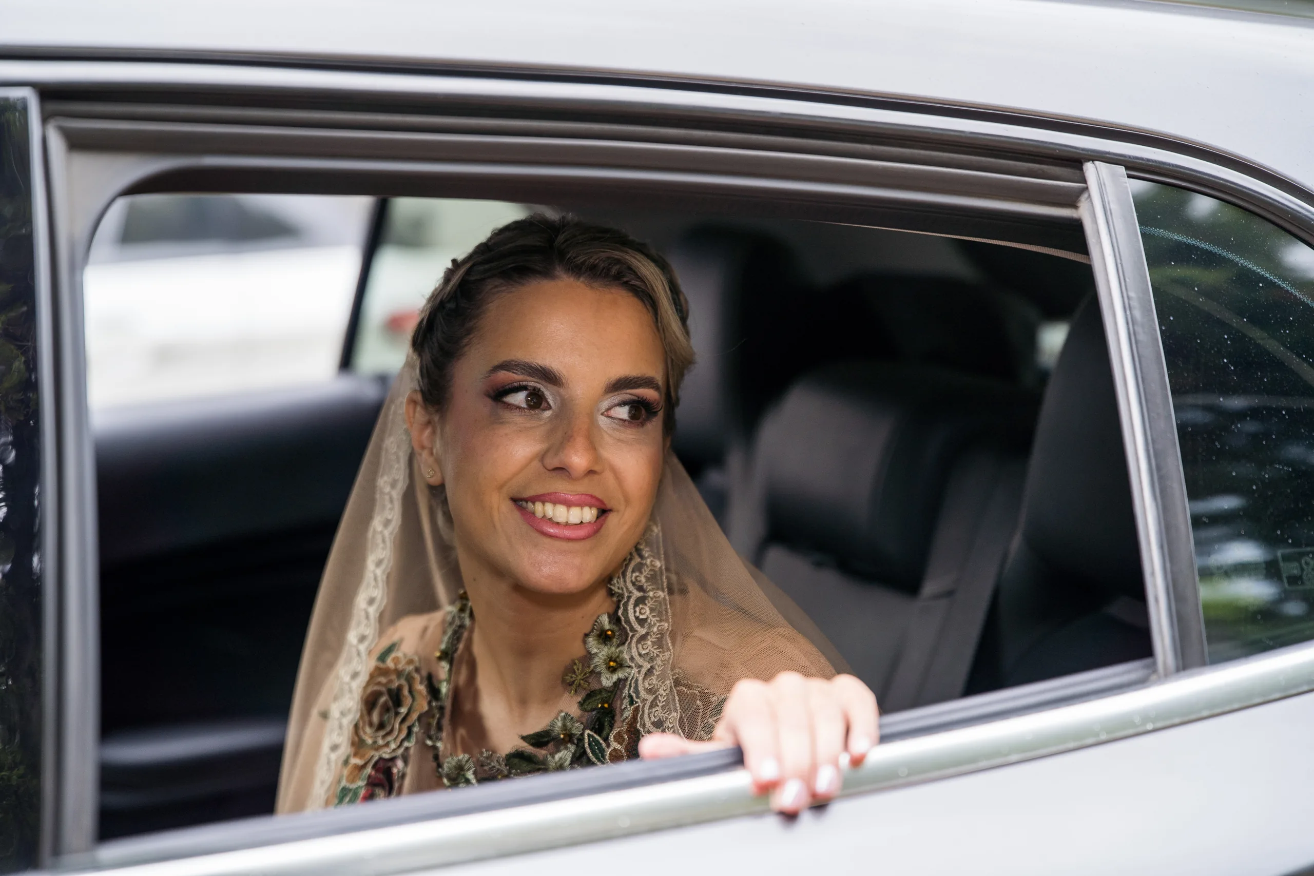 The bride smiling from the car window