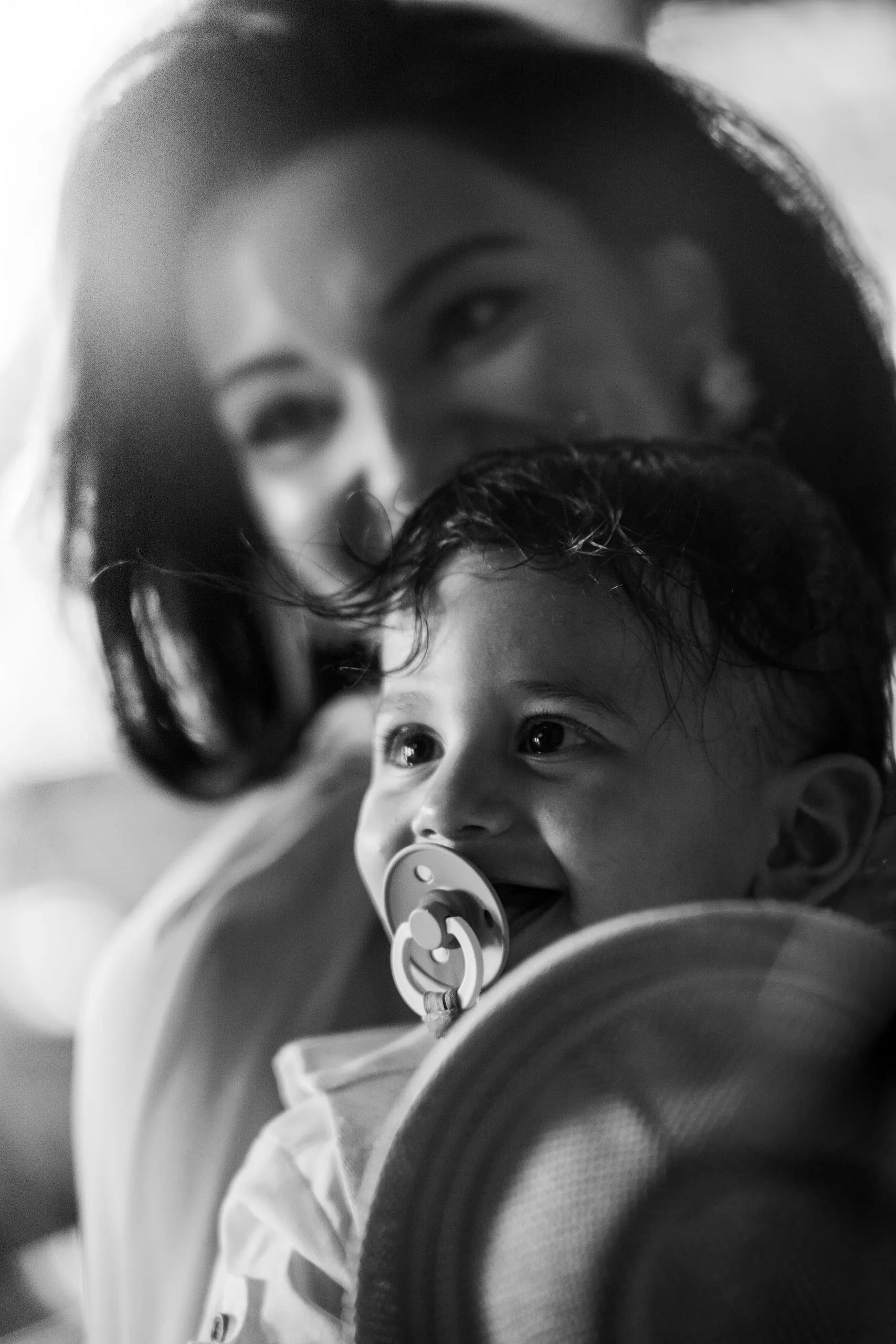 Black-and-white close-up of the bride holding the baby