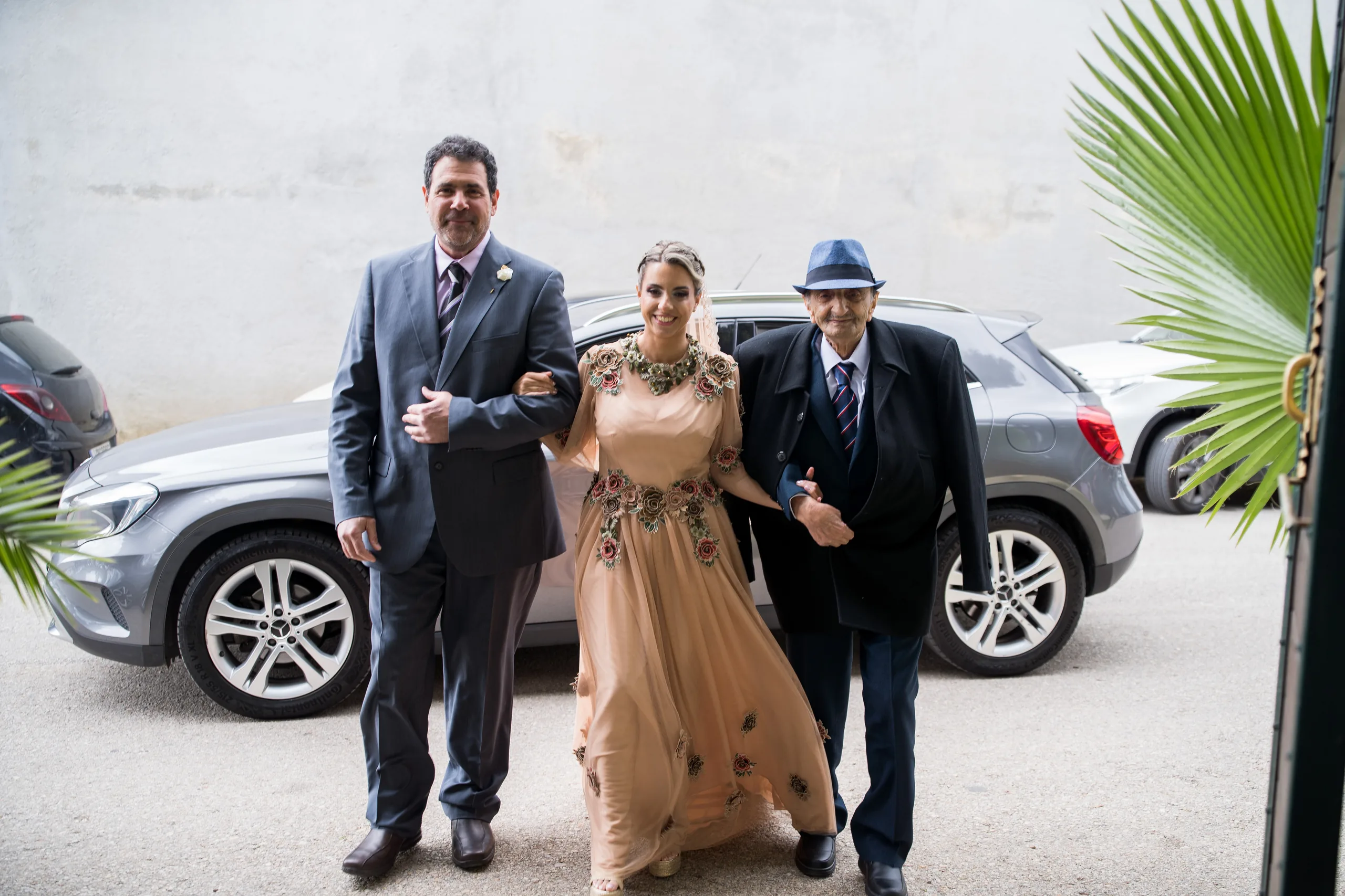 The bride arriving on the arms of two men