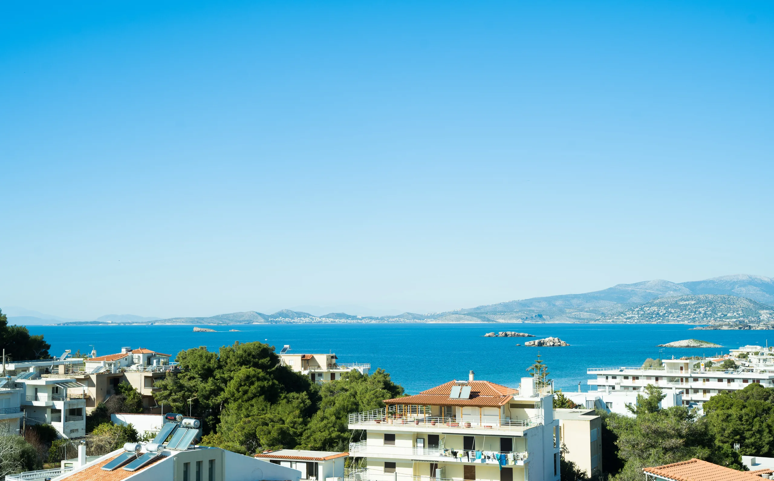 Πανοραμική θέα πάνω από τις στέγες προς τη θάλασσα και τα νησιά