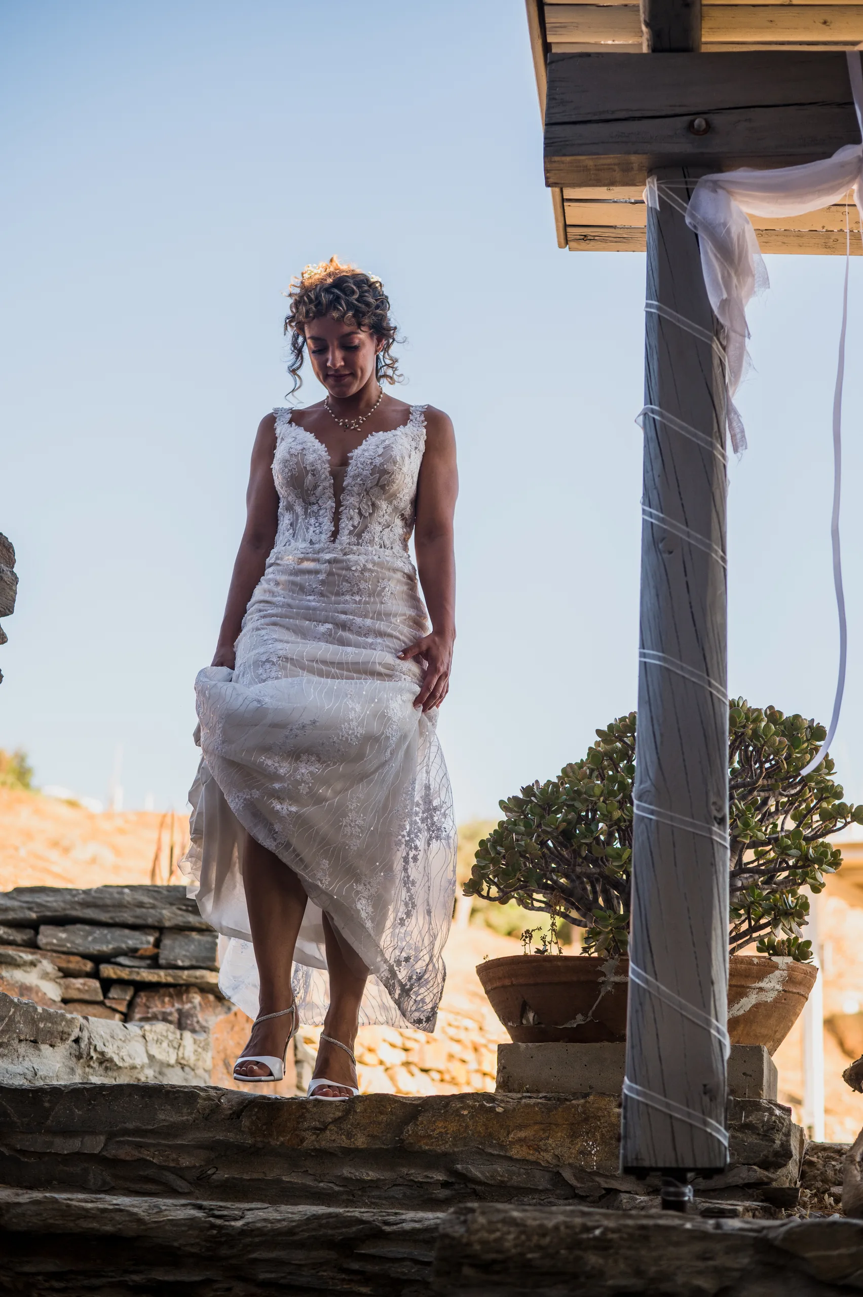 The bride walking down stone steps in the sun