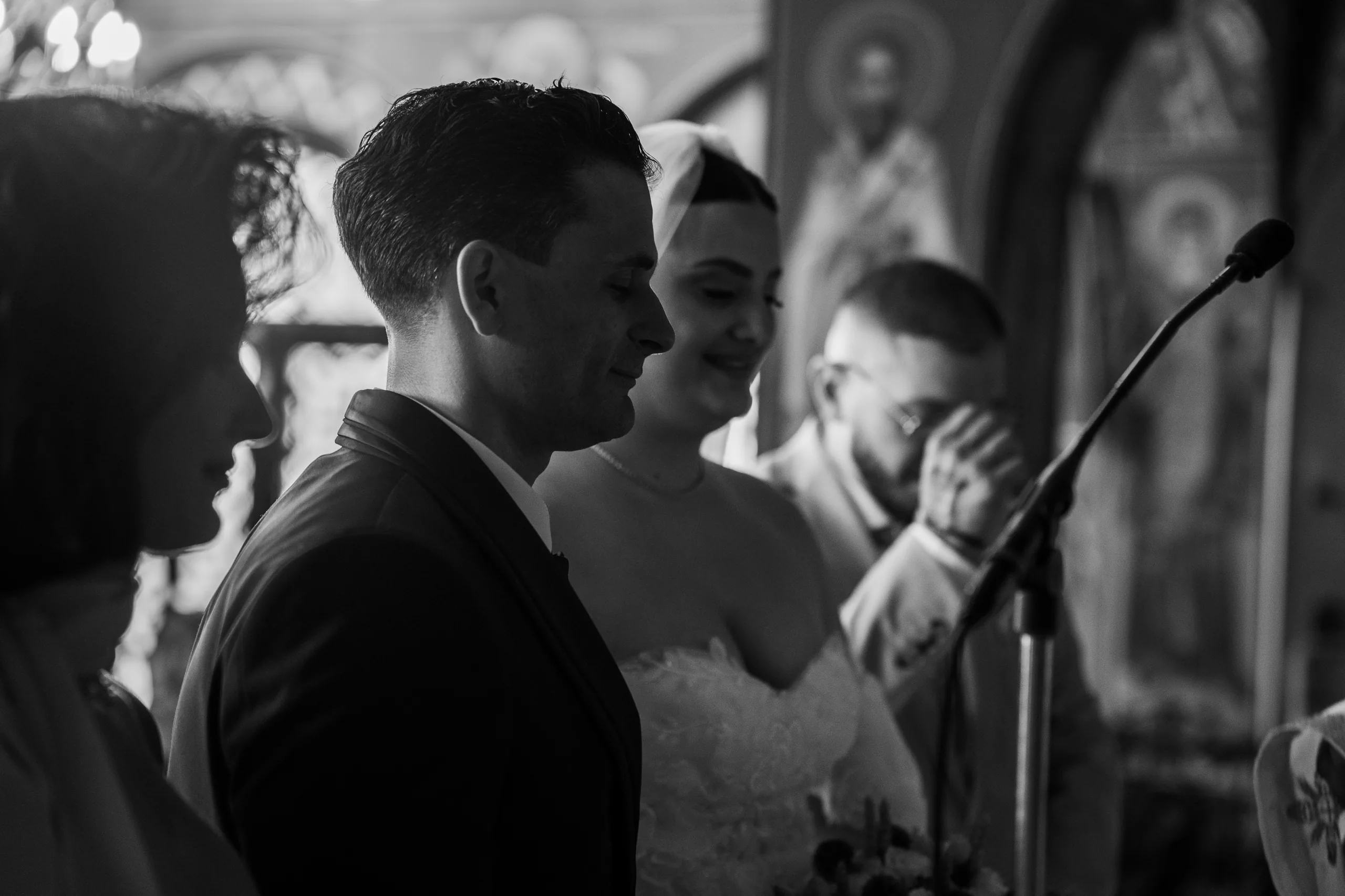 Black-and-white photo of the couple smiling during the ceremony