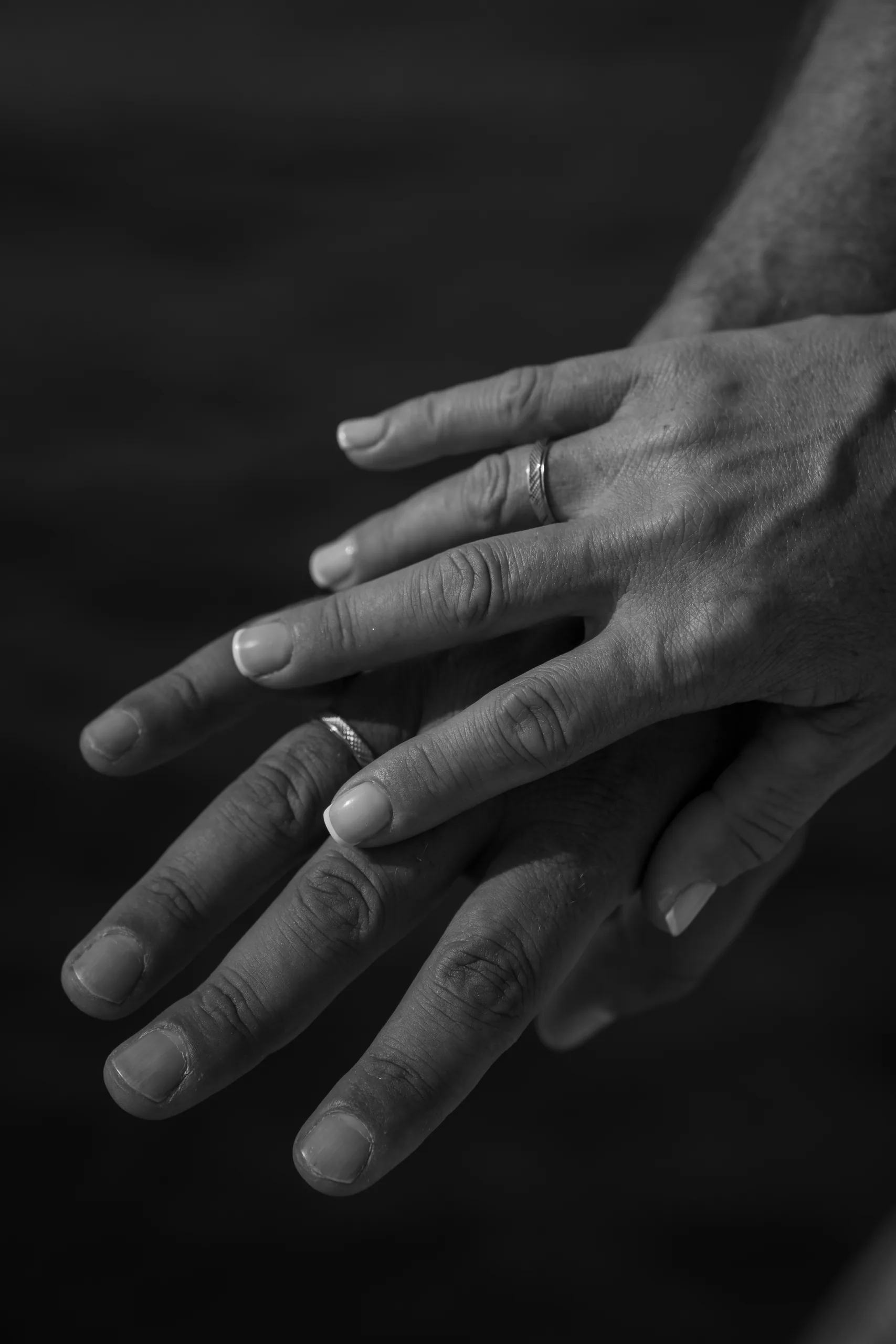 Ασπρόμαυρο κοντινό στα χέρια τους με τις βέρες