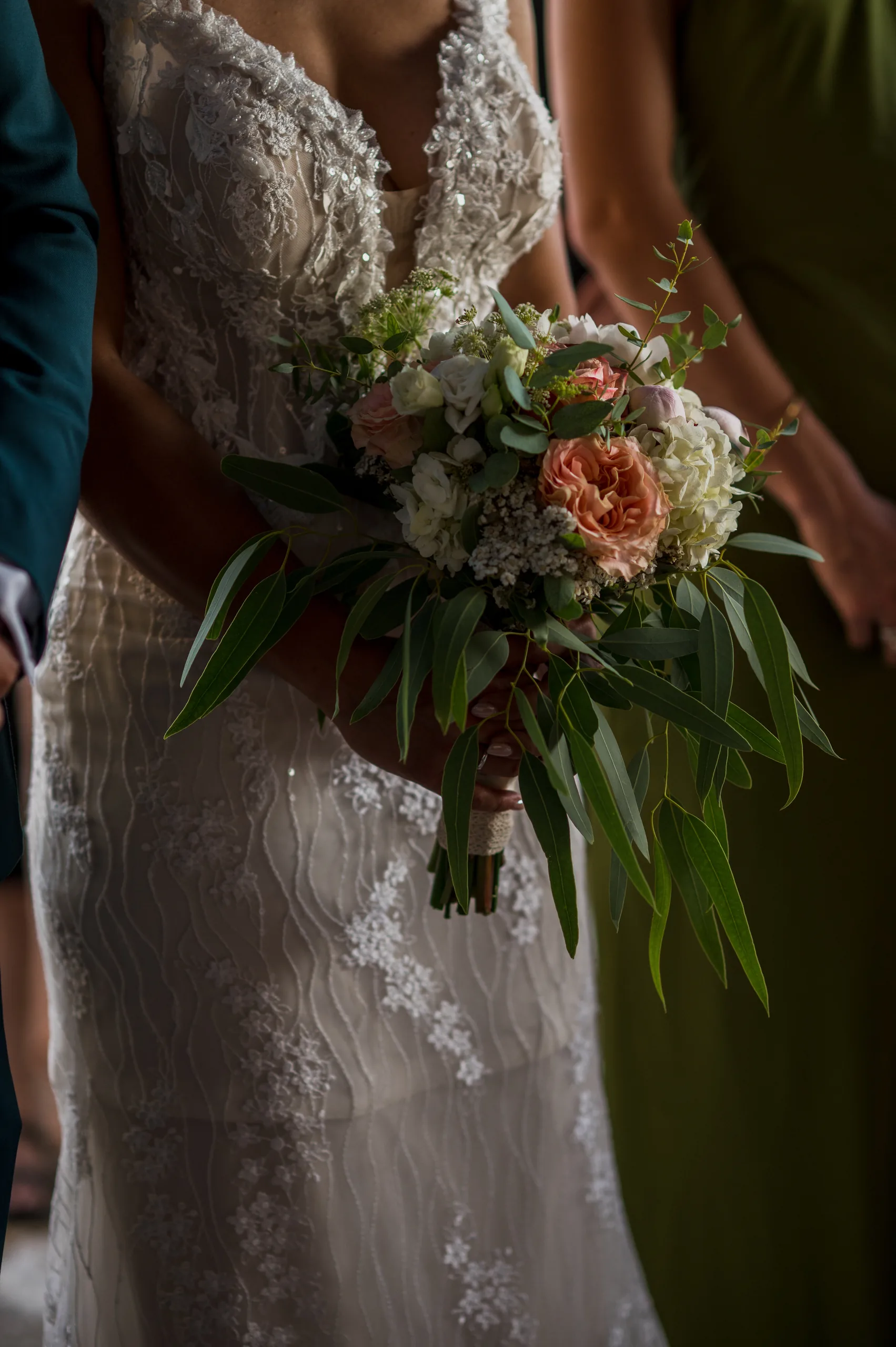 The bride holding her bouquet of roses and eucalyptus