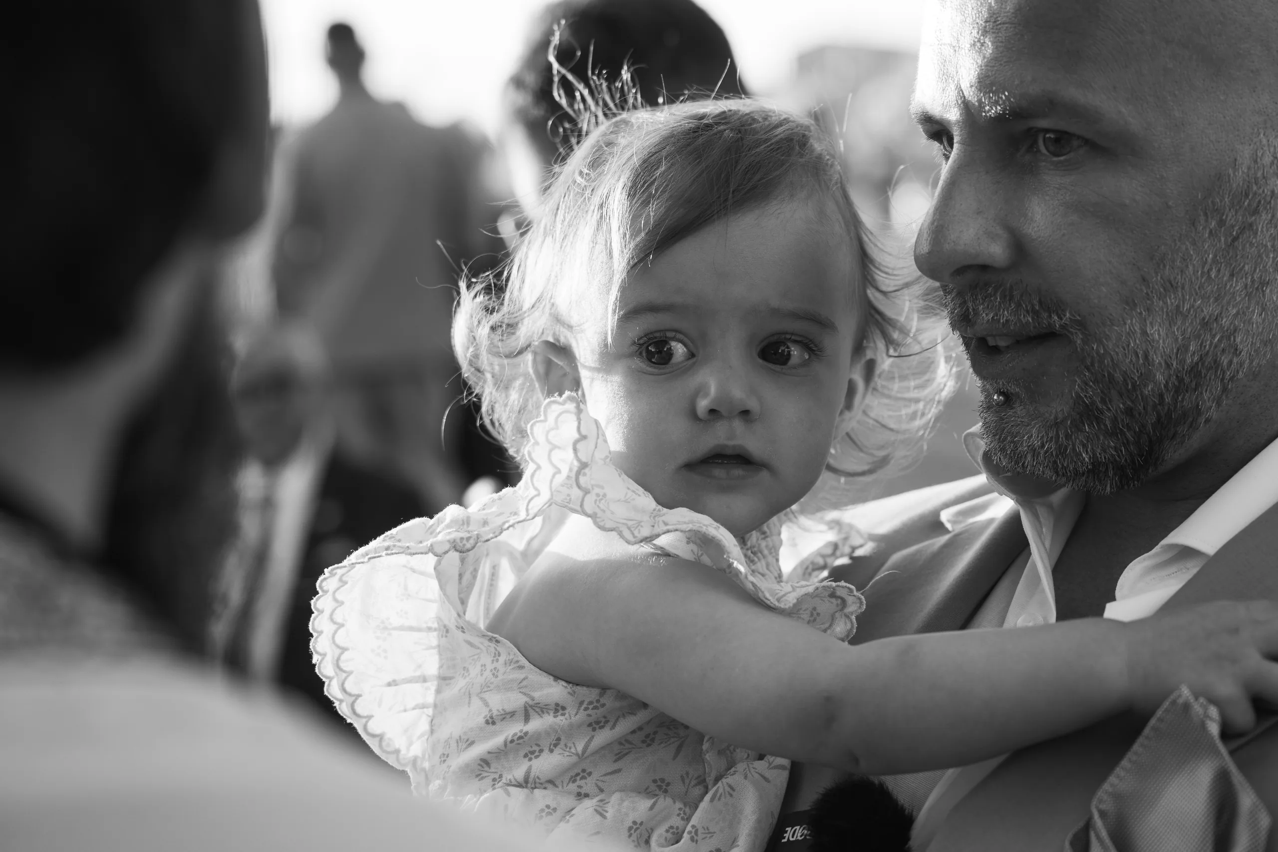 Ασπρόμαυρη φωτογραφία του κοριτσιού στην αγκαλιά ενός καλεσμένου