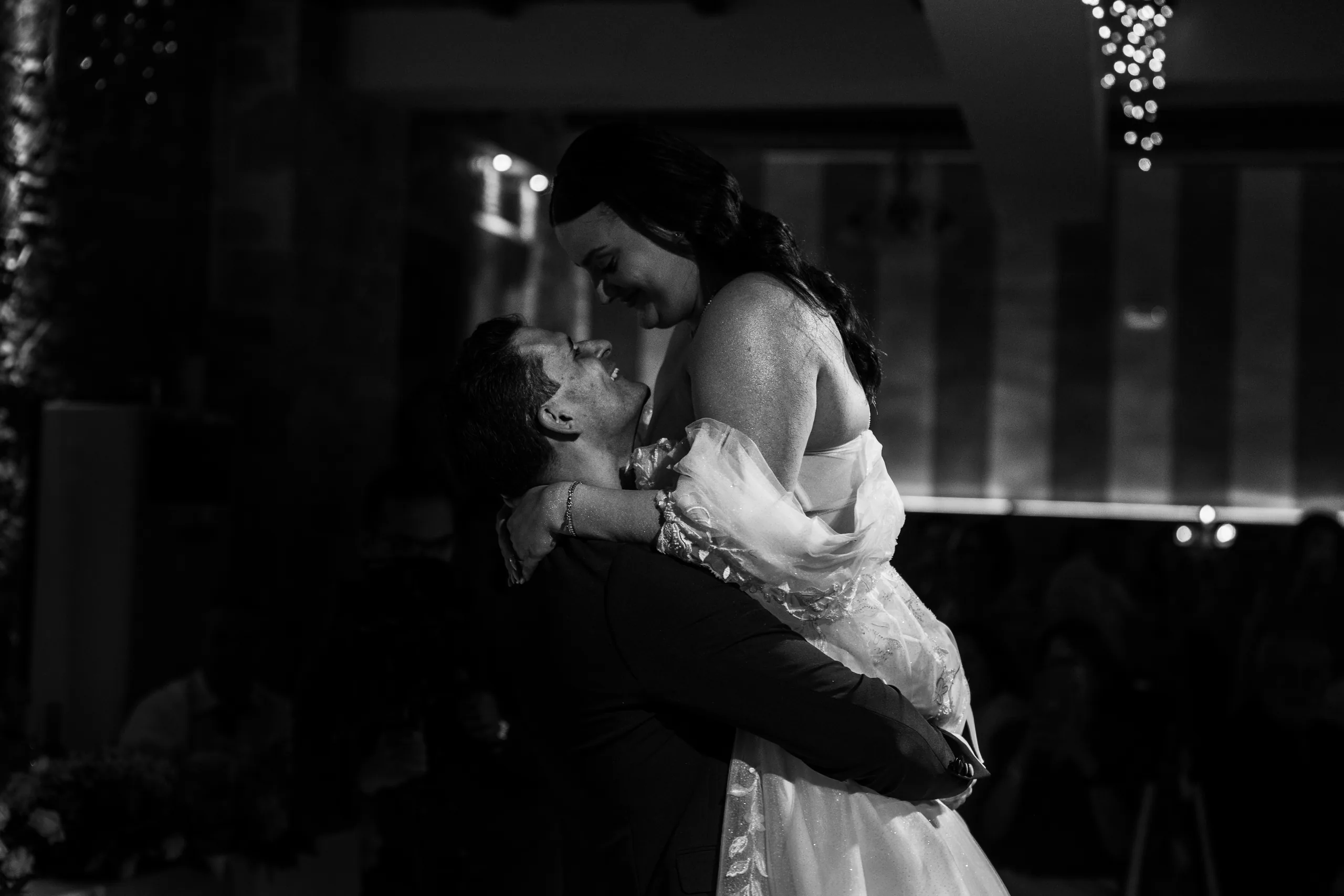 Black-and-white photo of the groom lifting the bride on the dance floor