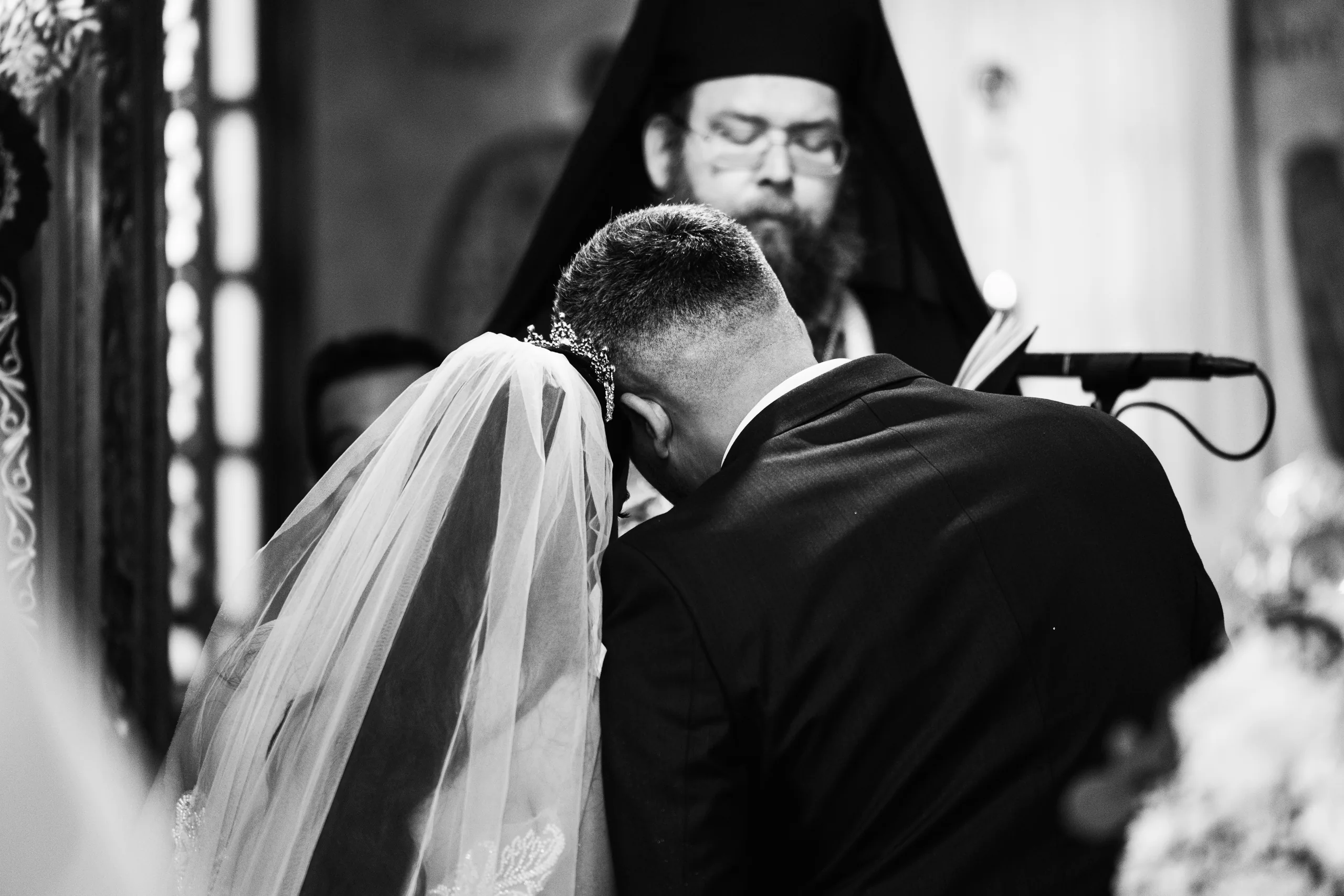 Ασπρόμαυρη φωτογραφία του ζευγαριού μπροστά στον ιερέα