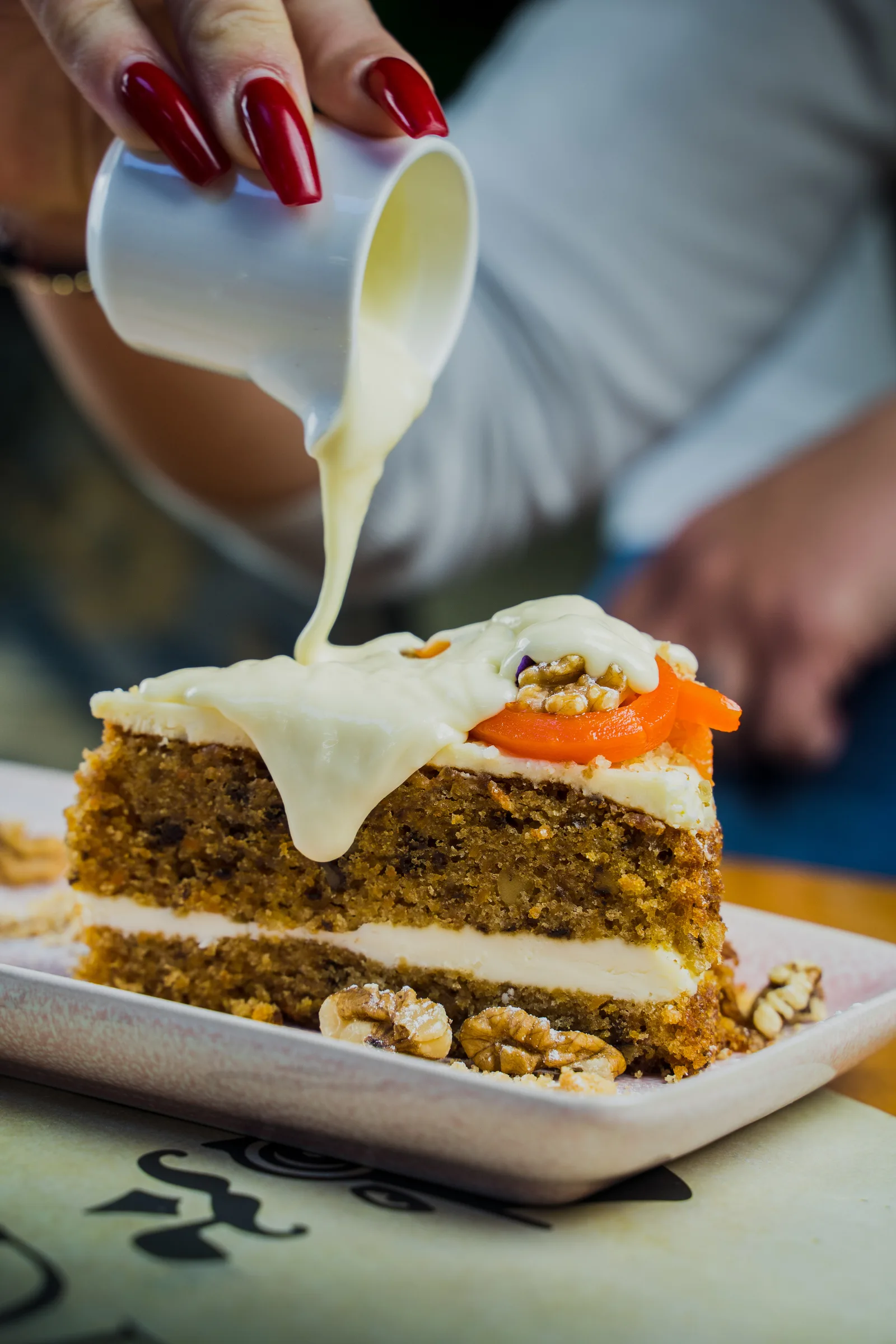 Cream poured over a slice of carrot cake
