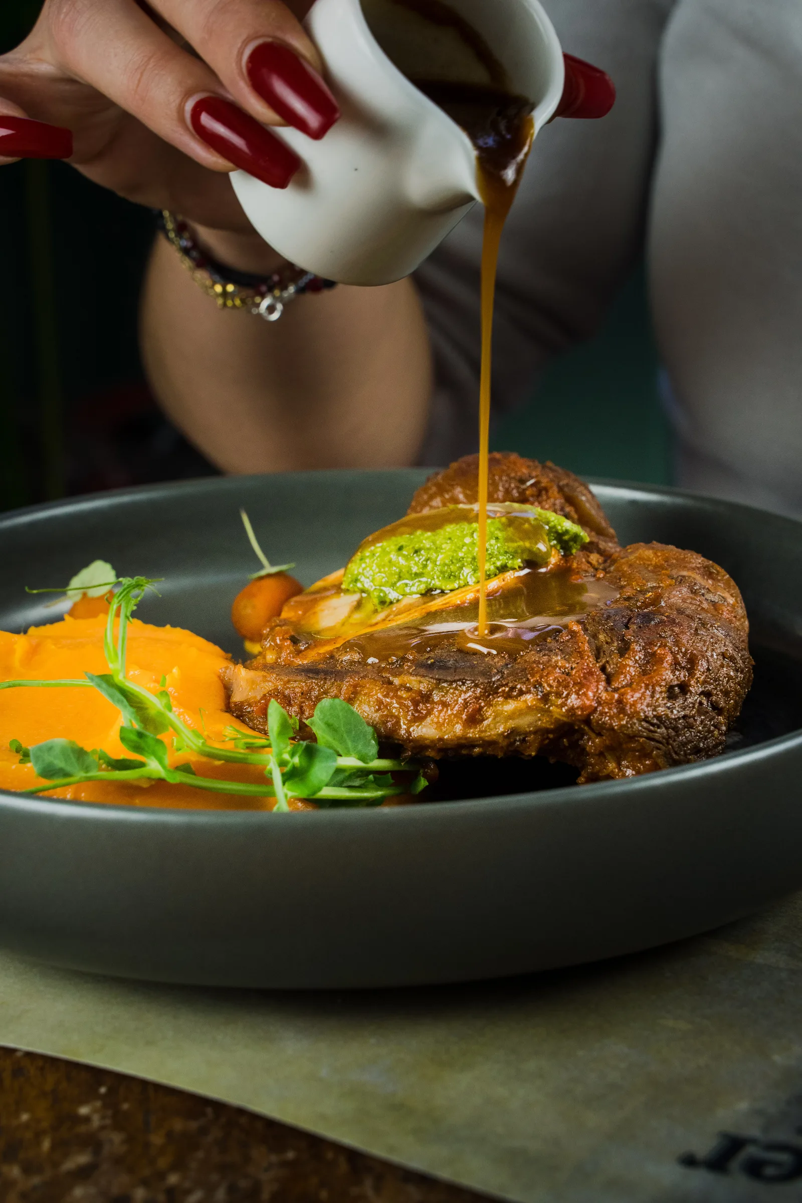 Sauce poured over a meat dish with vegetable purée
